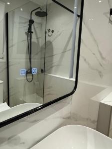 a shower with a glass door next to a toilet at Bettys rooms in Paralio Astros +45 photos