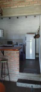 a kitchen with a white refrigerator and a counter at El Campito casa frente al río in Villa Carlos Paz +11 photos
