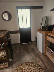 a room with a black door and a table at Studio tout confort in Blaye-les-Mines