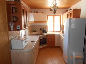 a kitchen with a white refrigerator and a window at Sykorova Chalupa in Suchá Rudná