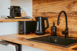 a kitchen counter with a sink and a coffee maker at Riverline Apartman in Odorheiu Secuiesc