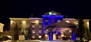 a hotel with a blue lighted building at night at Holiday Inn Express Airdrie by IHG in Airdrie