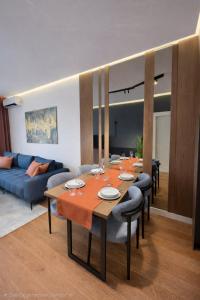 a living room with a table and a blue couch at Urban Forest Apartment - with free Garage in Podgorica