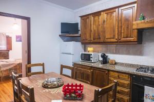 a kitchen with a wooden table and a kitchen with a microwave at Casa do Palheiro in Campo do Gerês
