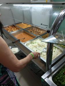 a person is preparing food in a buffet at Pousada Nascimento in Trindade