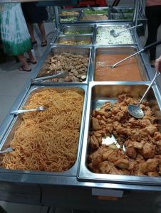a buffet of food with noodles and other foods at Pousada Nascimento in Trindade