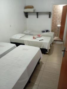 a group of three beds in a room at Pousada Nascimento in Trindade +5 photos