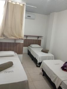a room with three beds in a room at Pousada Nascimento in Trindade
