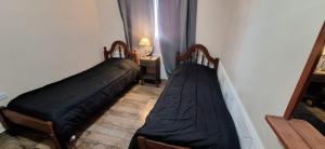 two beds in a room with a mirror at Victoriano in La Rioja