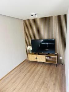 a living room with a flat screen tv on a stand at White Sun Apartment in Aizkraukle