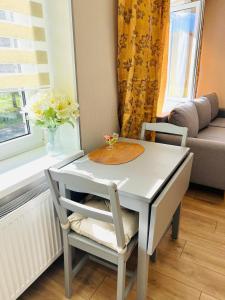 a small white table and chairs in a living room at White Sun Apartment in Aizkraukle +2 photos