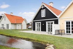 a black and white house next to a river at BV435-Blavand-Horns-Bjerge-3-59 in Blåvand