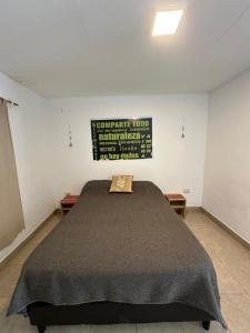 a large bed in a room with a sign on the wall at Huaka Guesthouse and Hostel in Cafayate