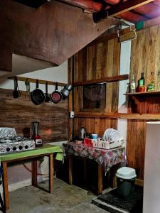 a kitchen with wooden walls and a table with pots and pans at Esperanza Casa de Huéspedes in Brisas de Zicatela