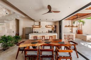 a kitchen and dining room with a wooden table and chairs at La Barra Resorts Luxury Villas in Paso Hondo