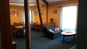 ein Wohnzimmer mit einem blauen Sofa und einem Tisch in der Unterkunft Hotel Mrázek in Pardubice