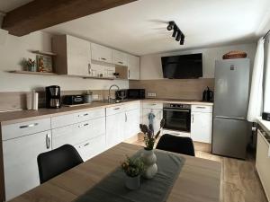 a kitchen with a table with chairs and a refrigerator at Ferienhaus Kluttig in Hörnitz