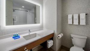 a bathroom with a sink and a toilet and a mirror at Holiday Inn Express Airdrie by IHG in Airdrie +27 photos