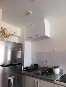 a kitchen with a stainless steel refrigerator and white cabinets at The harmony suit in San Antonio
