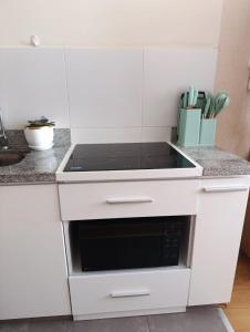 a white kitchen with a black stove top oven at The harmony suit in San Antonio