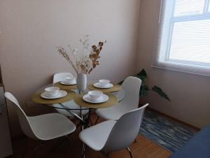 a dining room table with white chairs and a vase with flowers at The harmony suit in San Antonio