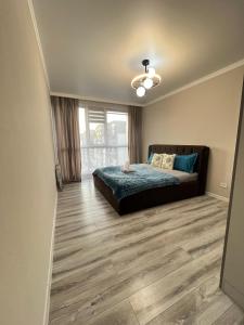 a bedroom with a bed and a large window at ЖК City plus Евродвушка in Almaty