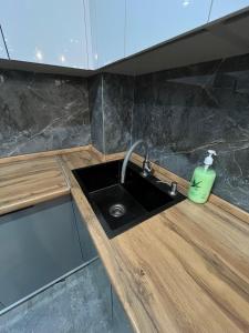a kitchen sink with a green soap bottle on it at ЖК City plus Евродвушка in Almaty