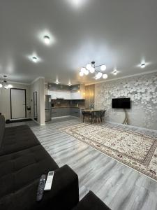 a large living room with a couch and a table at ЖК City plus Евродвушка in Almaty +9 photos