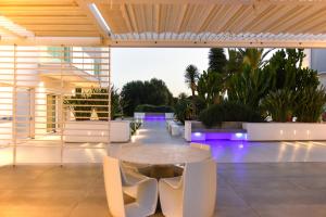 a patio with a table and chairs and purple lights at Villa VINNER - Monopoli in Monopoli