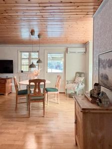a living room with a table and chairs and a couch at Levrasjön Lake House Private Pier in Bromölla