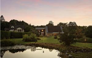 a house with a pond in front of it at Levrasjön Lake House Private Pier in Bromölla