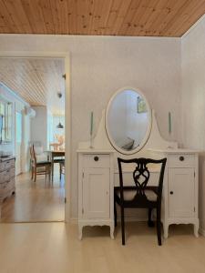 a room with a table with a mirror and a chair at Levrasjön Lake House Private Pier in Bromölla