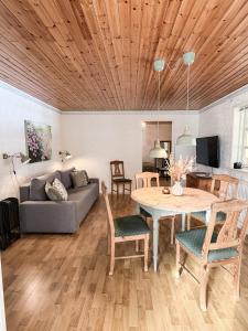 a living room with a table and a couch at Levrasjön Lake House Private Pier in Bromölla