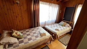 a bedroom with two beds and a window in it at Hotel Cabañas Caribe in Los Vilos