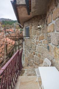a stone building with a table and chairs on a balcony at Casa da Cuca in Campo do Gerês