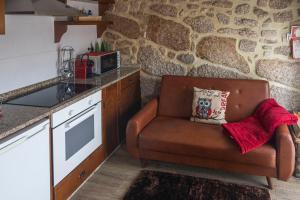 a kitchen with a brown chair in a kitchen at Casa da Cuca in Campo do Gerês