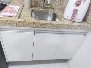 a kitchen counter with white cabinets and a sink at Juhh Bella in Botucatu +33 photos