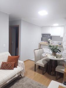 a living room with a white couch and a table at Juhh Bella in Botucatu