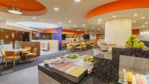 a restaurant with a buffet line with tables and chairs at Camino Real Aeropuerto in Mexico City