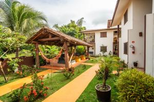 a garden with a gazebo next to a house at Pousada das Estrelas in Itaúnas