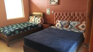 a bedroom with a bed and a bench and a bed and a window at Hostel Del Piamonte 2 in Quito