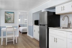 a kitchen with a black refrigerator and a table at Sabal Palms Inn in St. Pete Beach