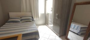 a small bedroom with a bed and a mirror at Studio Centro Floripa 02 in Florianópolis