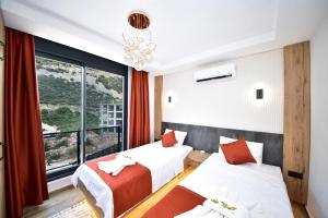 two beds in a room with a large window at Villa Belmora Villa Asgora in Demre