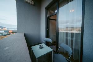 a room with a table and chairs and a window at Riverline Apartman in Odorheiu Secuiesc