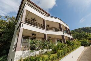 an apartment building with a balcony and plants at Hotel Las Lomas in Nandayure