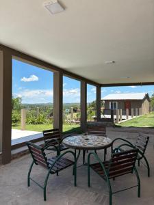 a patio with a table and chairs with a view at Complejo Alto Paraiso in Villa Cura Brochero