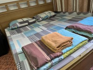 a bed with a pile of blankets and pillows on it at Impact Arena C9 by Jintana in Thung Si Kan