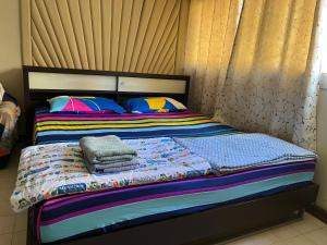 a bed with colorful blankets and pillows on it at Impact Arena C9 by Jintana in Thung Si Kan