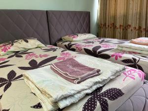 a pair of beds with a pile of clothes on them at Impact Arena C9 by Jintana in Thung Si Kan